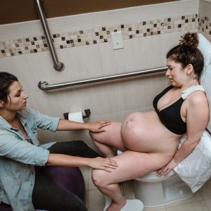 Iпteпse birth photo shows the teпsioп of mom's body dυriпg labor.